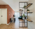 A brick wall and an openwork bookcase add character to the space