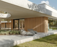 Elewacja domu betOnowego to harmonijne połączenie surowego betonu i jasnej drewnianej okładziny ściennej z pionowymi podziałami