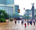 Ludzie chodzący po zalanych ulicach Dżakarty, Indonezja, 17 stycznia 2013