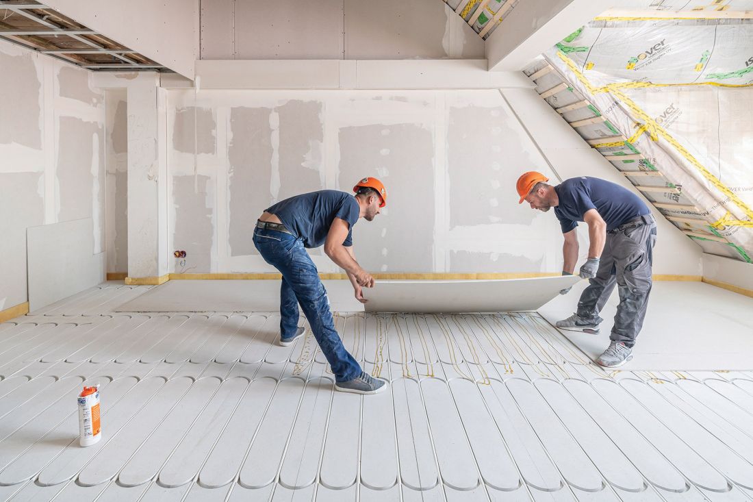 Montaż dodatkowej płyty gipsowo-włóknowej fermacell® o gr. 10 mm, która jest przyklejana i przykręcana jako przykrycie instalacji ogrzewania podłogowego fermacell® Therm 25