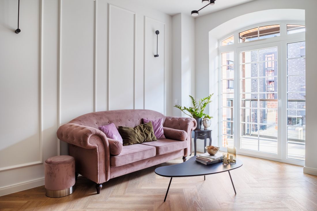 Centralnym punktem salonu jest sofa w brudnoróżowym kolorze