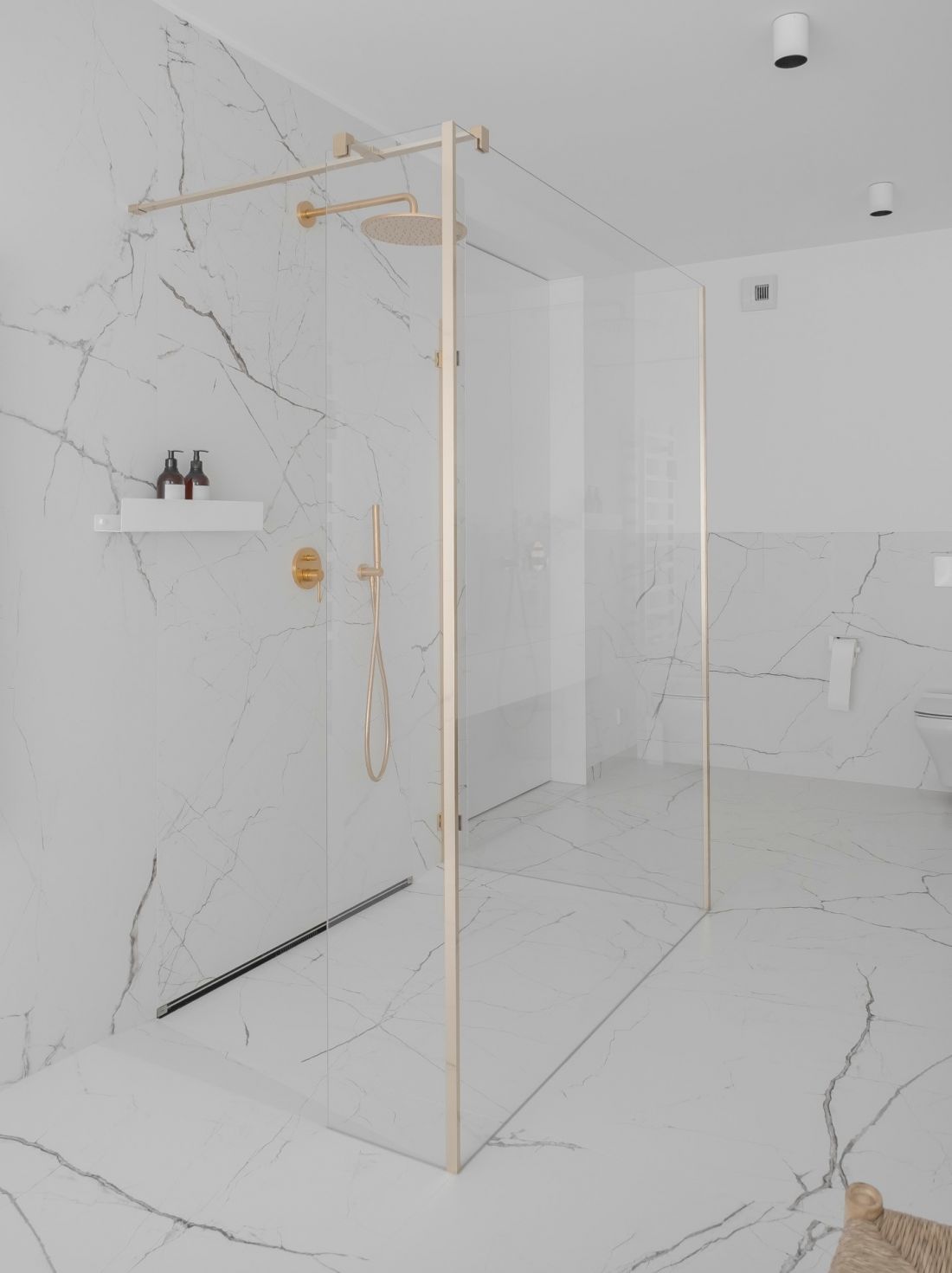Minimalistyczny prysznic typu walk-in nie przytłacza przestrzeni