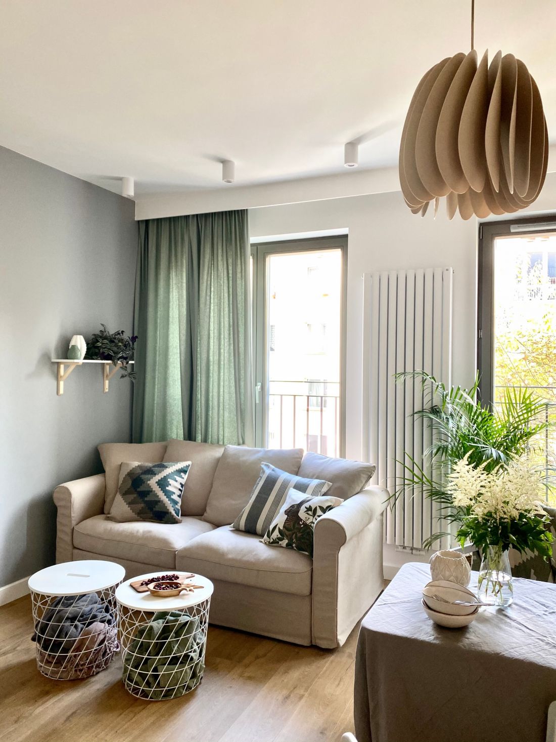 Prosta sofa i nowoczesne stoliki kawowe łączą się z minimalistyczną kuchnią