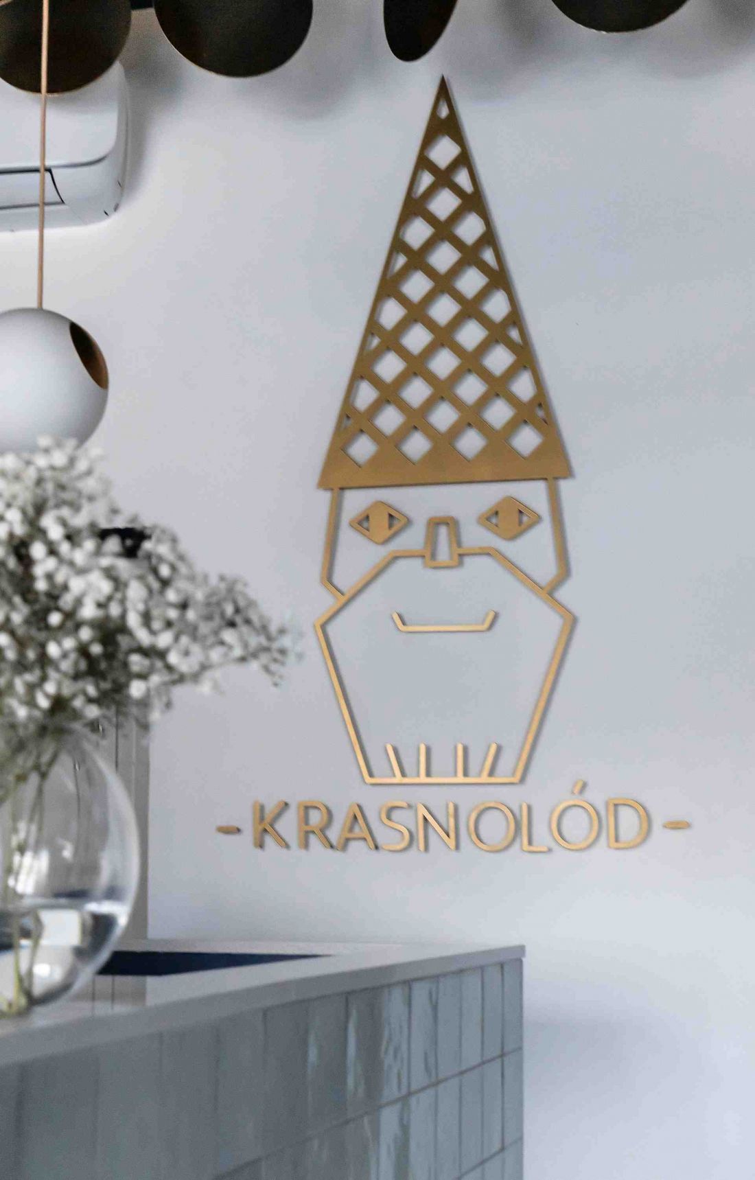 logo lodziarni przedstawia krasnala z rożkiem na głowie