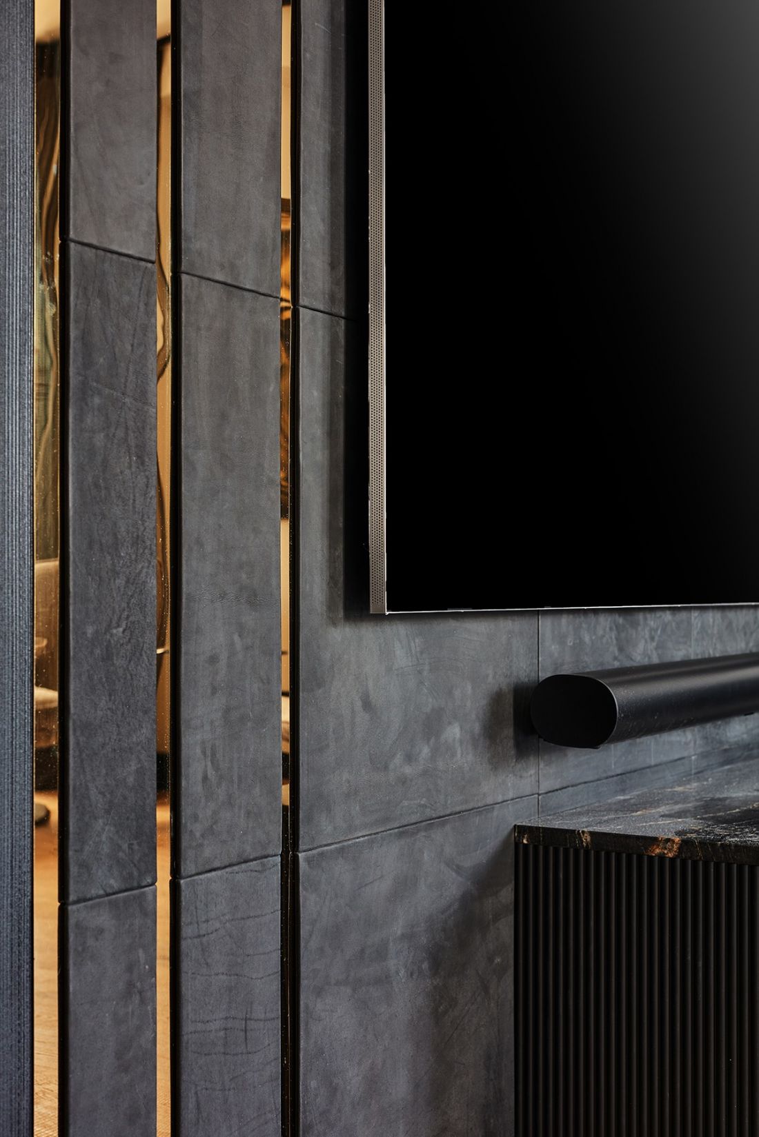 Ściana z TV została obita panelami z czarnej skóry