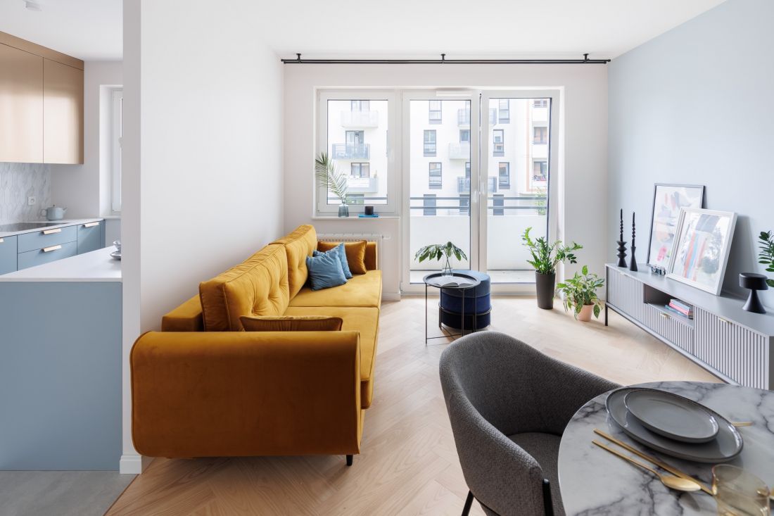 Odważnym akcentem w salonie jest żółta sofa