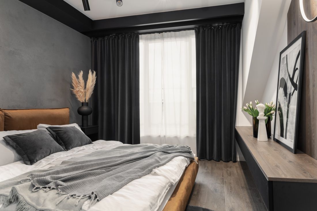 Sypialnia znajduje się na poddaszu. Architektka zastosowała więc grube ciemne zasłony, które chronią przed ostrym światłem