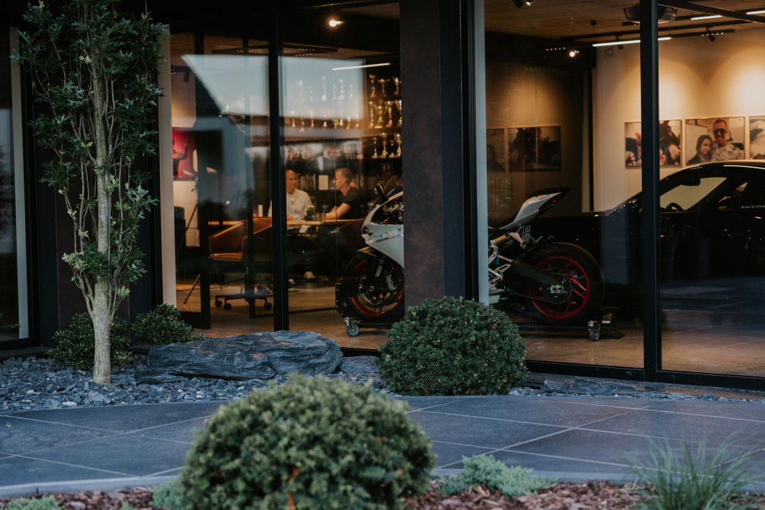 W przeszklonych garażach wyeksponowane zostały motocykle oraz sportowe samochody
