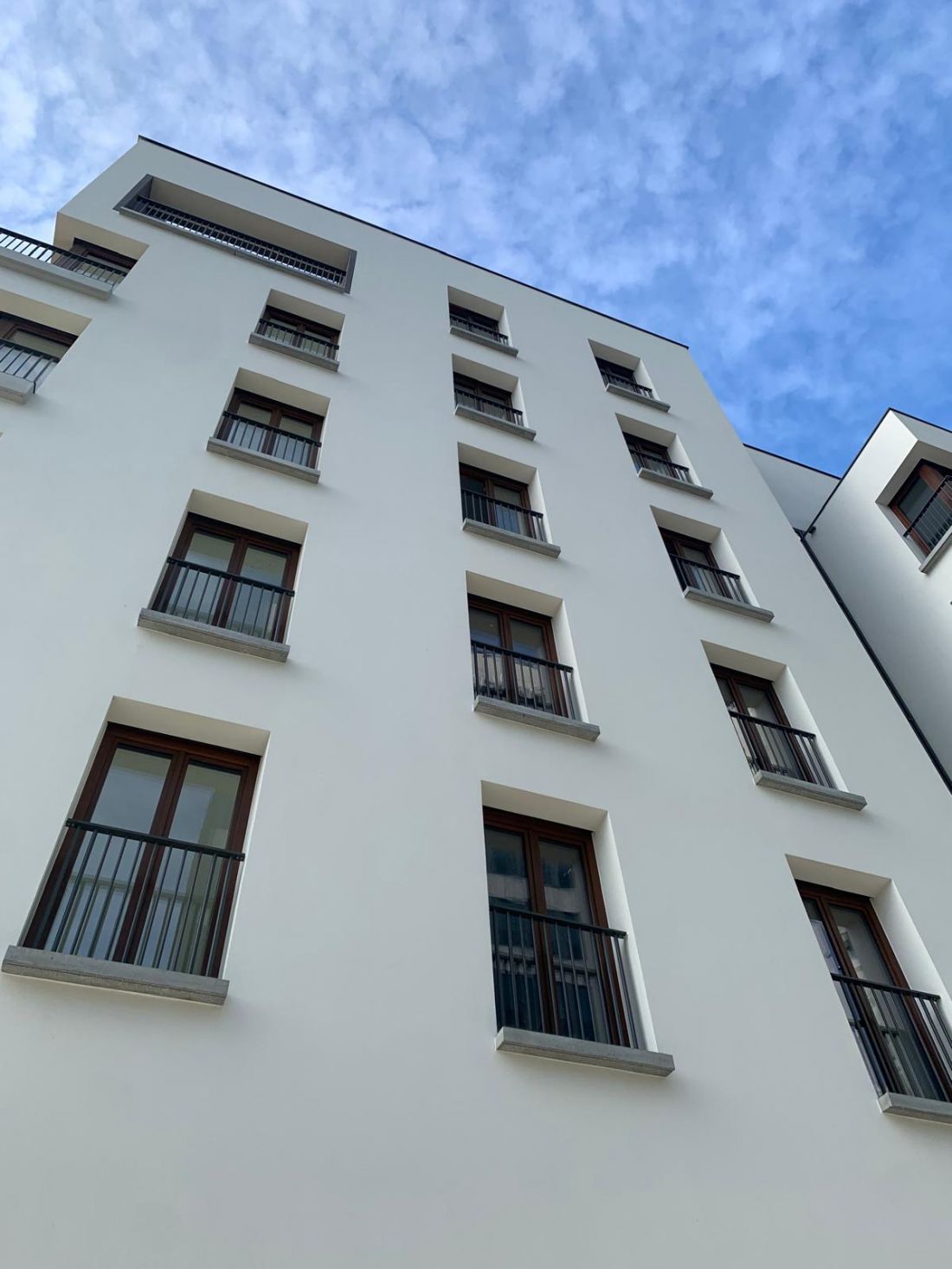 Część mieszkaniowa, która bezpośrednio sąsiaduje z wieżami Sea Towers ma minimalistyczną elewację