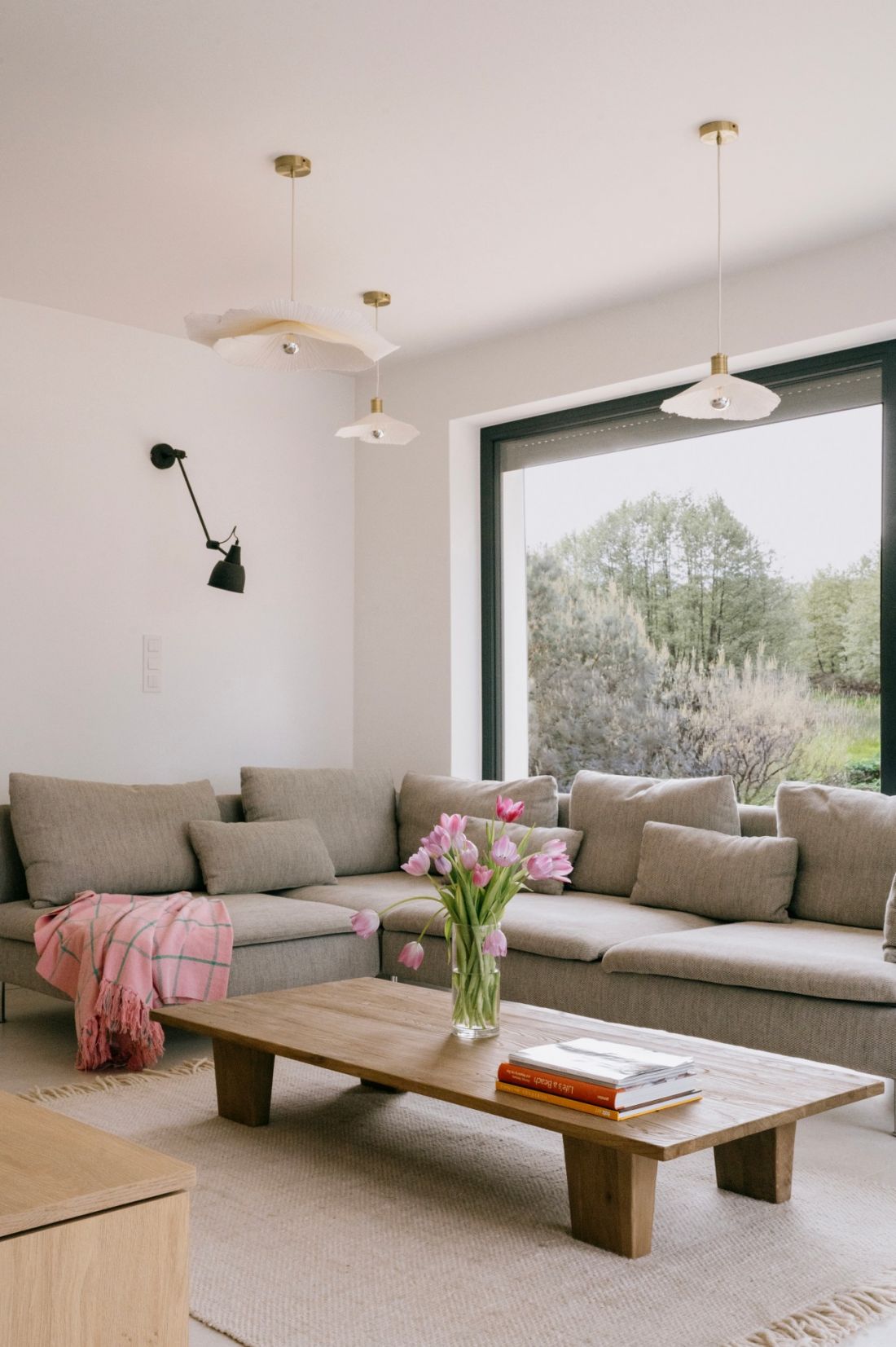 Szara modułowa sofa harmonizuje z drewnianym stolikiem