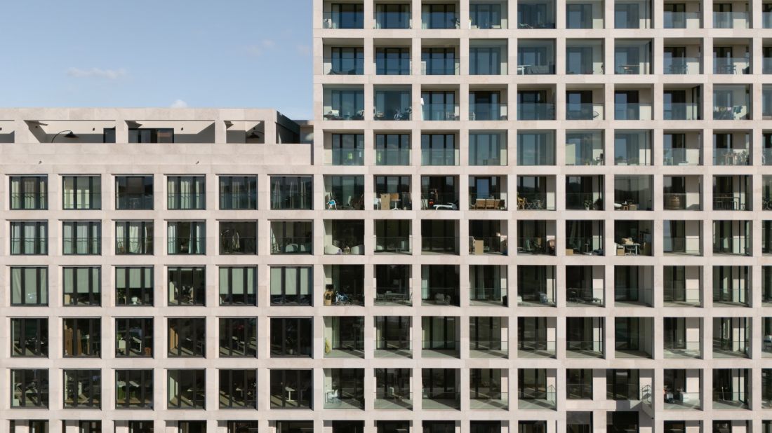 Kompleks mieszkalny Scheldehof w Nieuw Zuid, w Antwerpii - wapienne elementy tworzą ażurową strukturę, które oplatają ściany niczym sieć