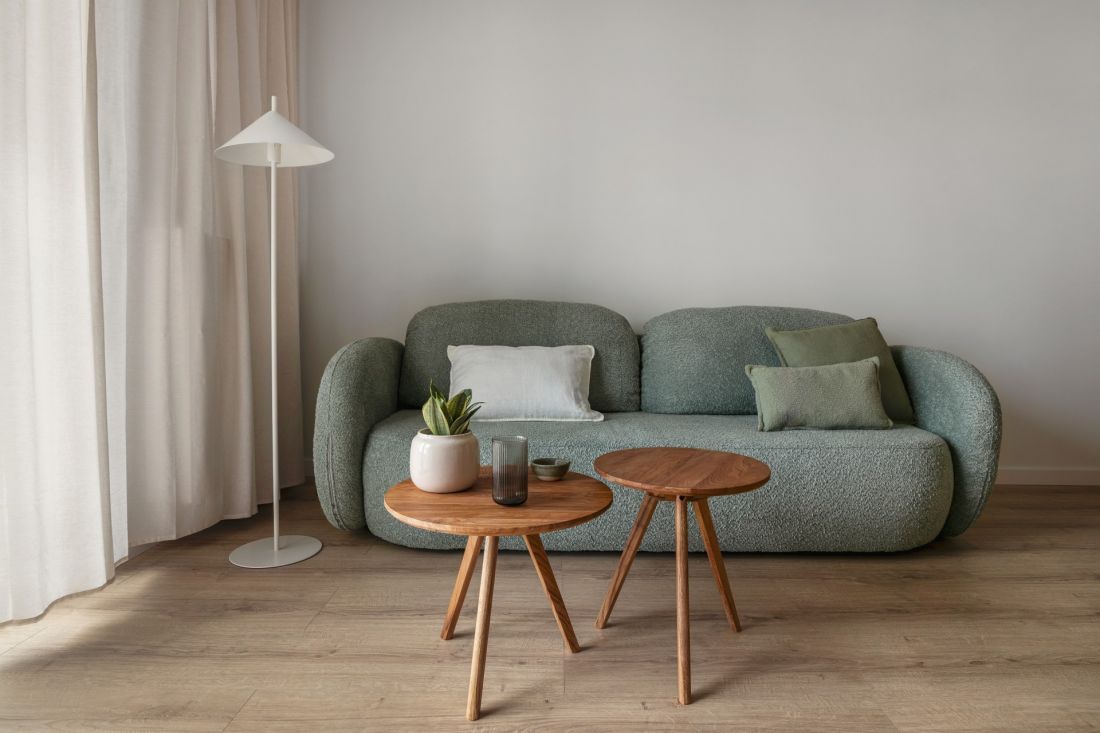 Centralnym elementem strefy wypoczynkowej jest zielona sofa