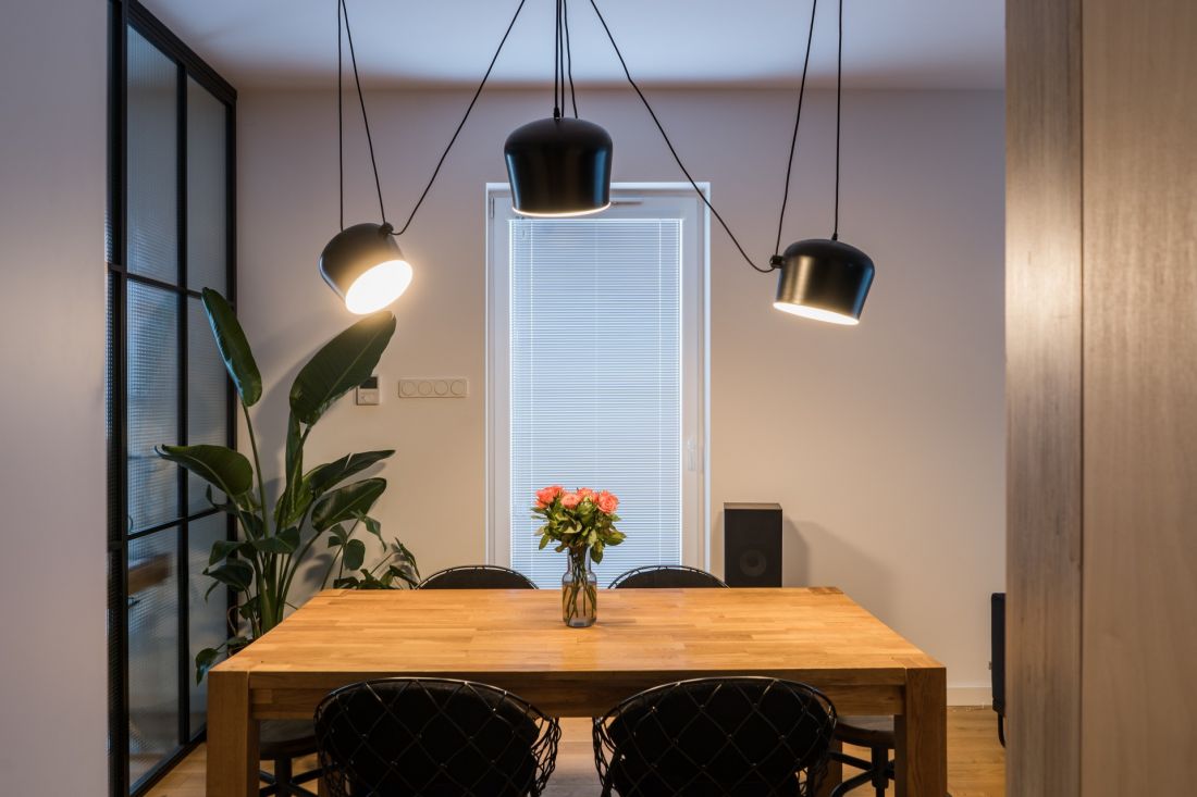Nad stołem w jadalni zawisła ciekawa kompozycja z czarnych lamp