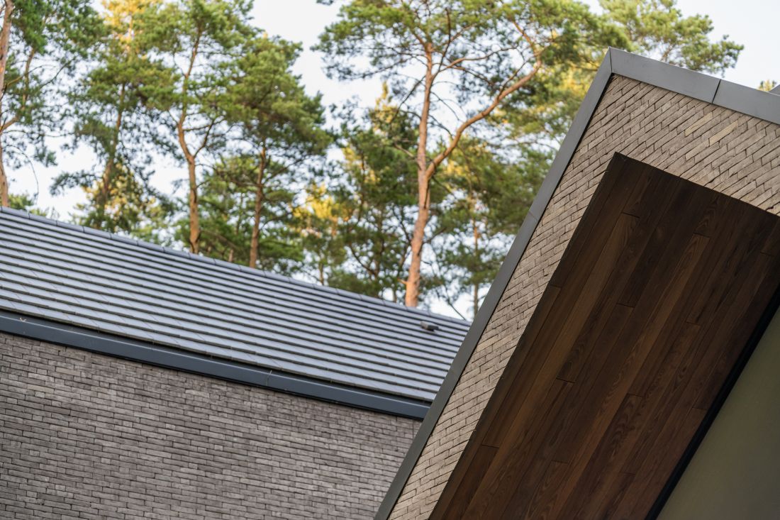 Dwuspadowe dachy wykończono płaską dachówką ceramiczną