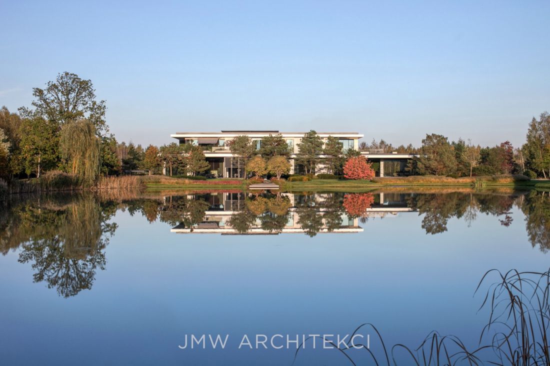 Lakefront Residence jest usytuowana bezpośrednio nad wodą, co sprawia, że tafla stawu odbija bryłę budynku, otaczającą roślinność i niebo