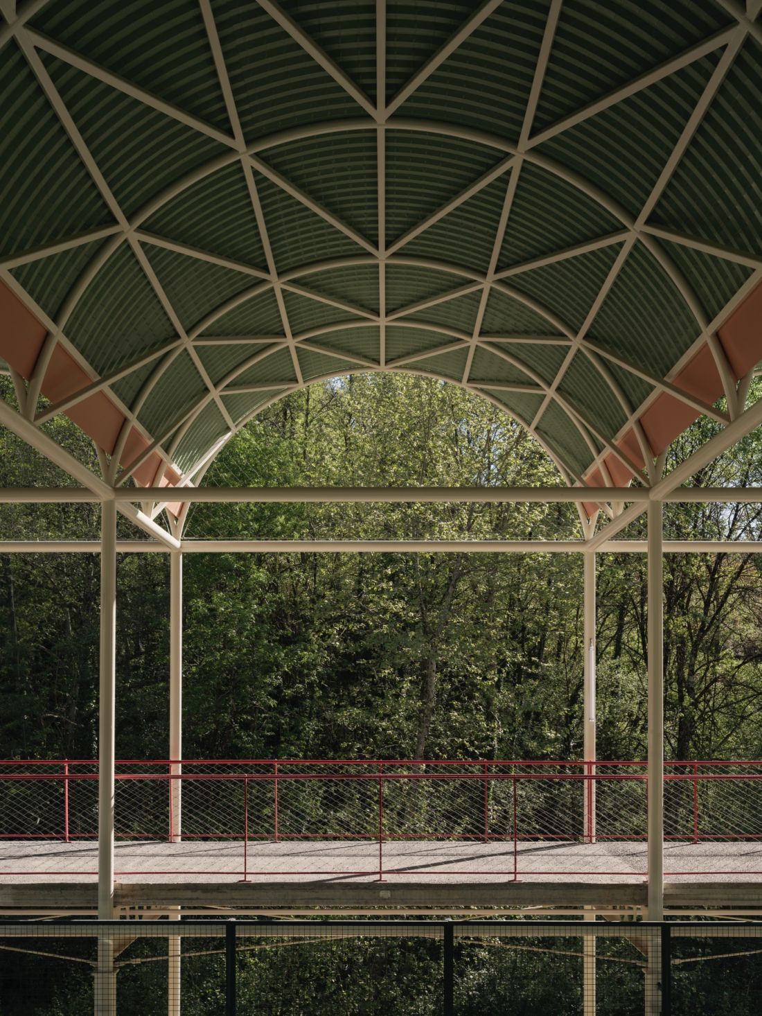 Kolory konstrukcji – miętowozielone dachy, kremowe belki i jaskrawoczerwone balustrady – tworzą spójną estetykę