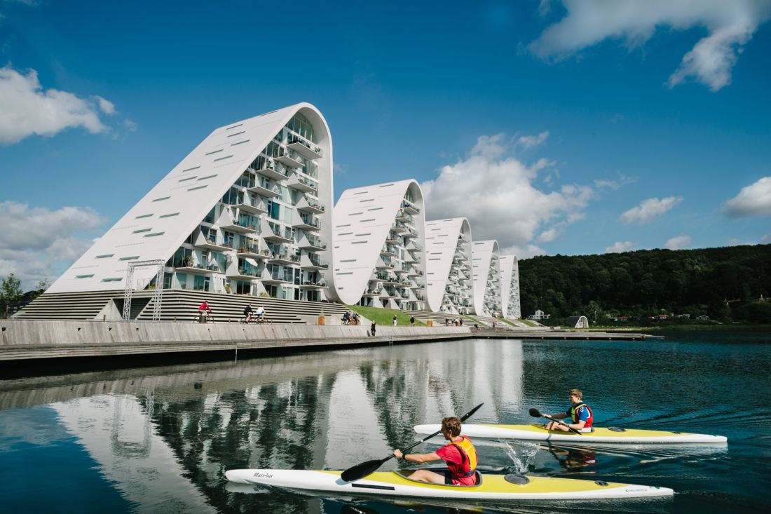 Kompleks apartamentowy The Wave w Vejle, w Danii - odbicia brył w spokojnej tafli fiordu potęgują wizualną harmonię kompleksu