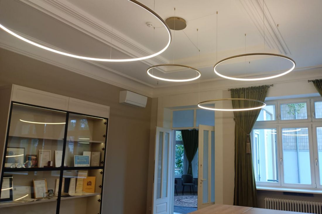 Złote lampy ring LED Orbit S w reprezentacyjnej przestrzeni biurowej