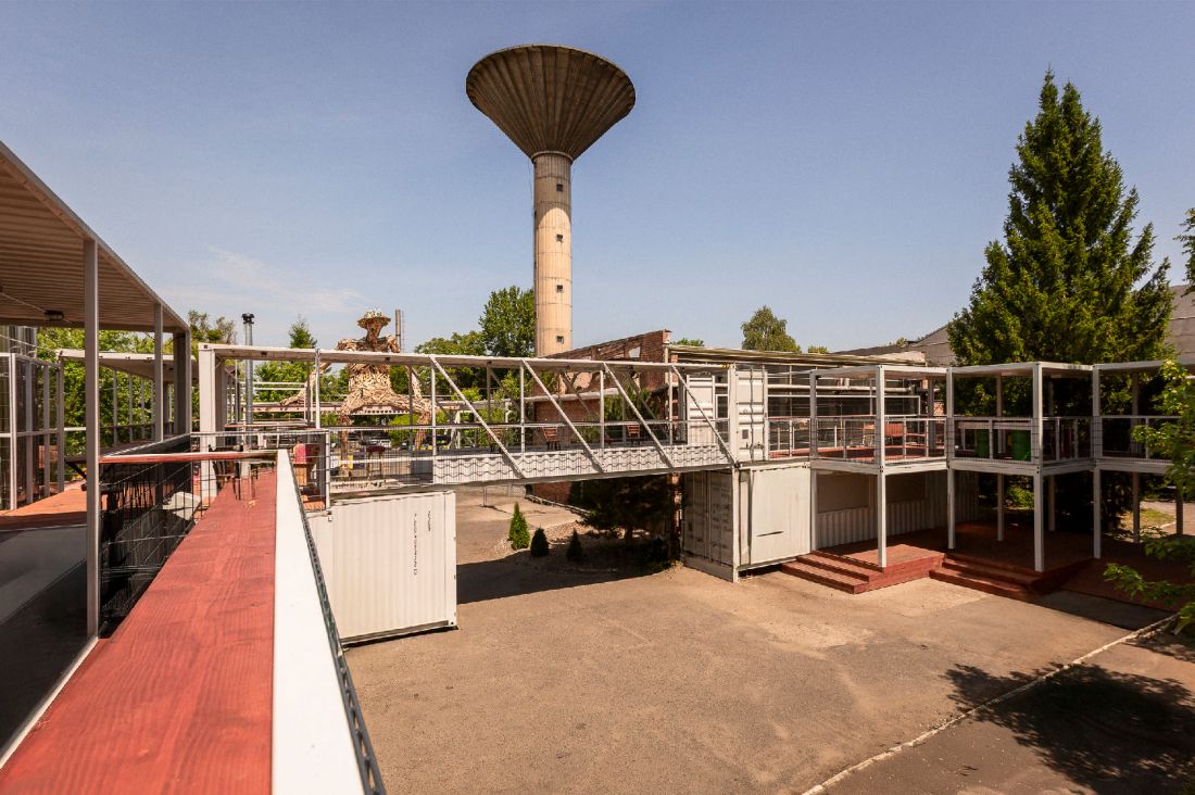 zlokalizowane pod charakterystyczną wieżą ciśnień kontenerowe miasteczko bezpośrednio nawiązuje do przemysłowej historii miejsca