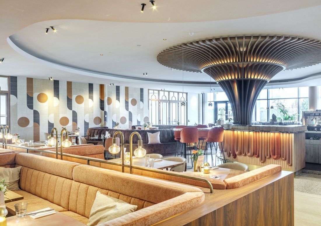 Geometryczne kształty jako szprosy w drzwiach, kształty barowych półek czy wzór tapety w restauracji wraz ze stylizowanymi krzesłami i fotelami przenoszą gości hotelowych w świat designu epoki lat siedemdziesiątych