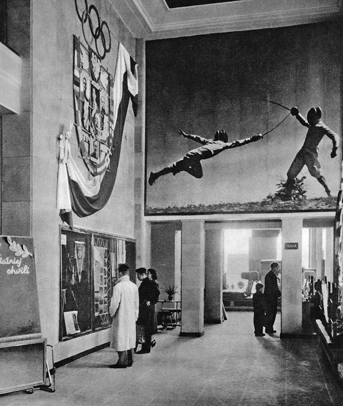 wnętrze sklepu sportowego przy placu Konstytucji 5 (blok 4A), wielkoformatowe zdjęcie i dekoracja o tematyce olimpijskiej, 1952-1954, proj.: Piotr Zajlich