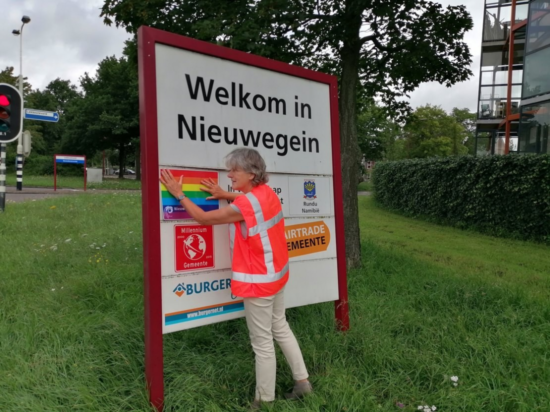 Nieuwegein, na zdjęciu radna Maria Schouten zakleja tęczą Puławy na tablicy z miastami partnerskimi