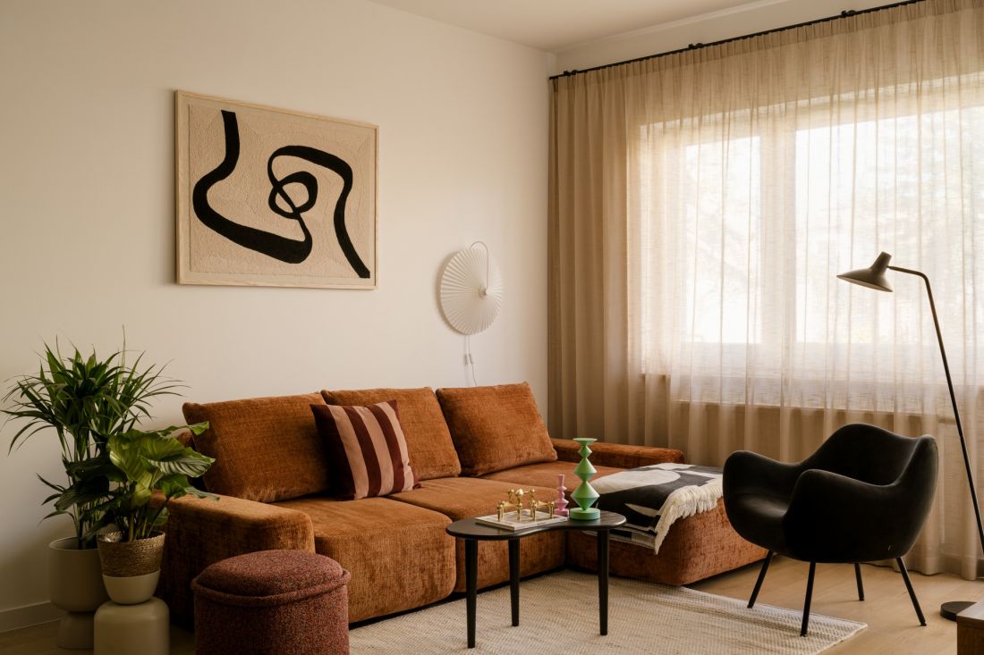 W salonie klimat mid-century jest najbardziej wyczuwalny - w obłych formach, drewnianych meblach i dekoracyjnych detalach