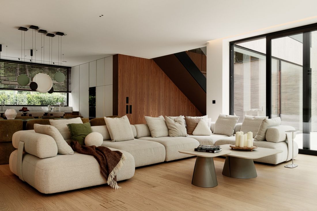 Miękka, modułowa sofa i duże przeszklenia budują spokojny charakter salonu otwartego na ogród