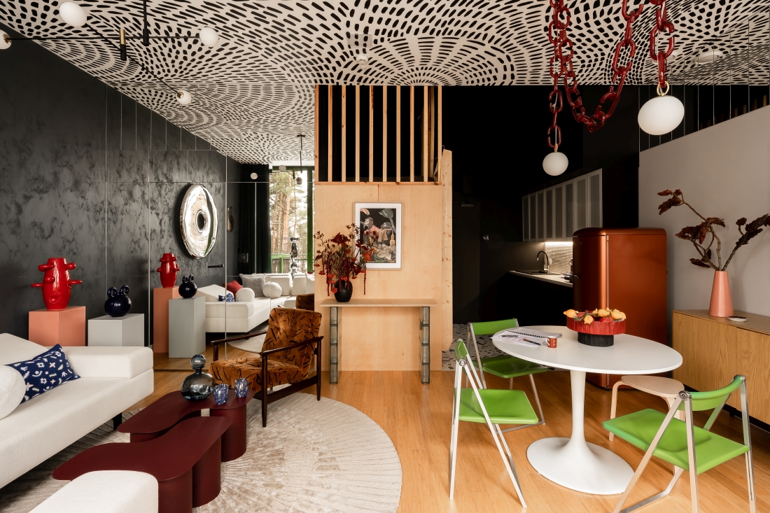 W salonie ciemną ścianę zestawiono z jasną sofą, drewnianą zabudową i designerskimi dodatkami. Centralnym akcentem jest <span style='color: var(--color-header);'><span style='color: var(--color-header);'><span style='color: var(--color-header);'><span style='color: var(--color-header);'>lustro</span></span></span></span> Rondo projektu Oskara Zięty