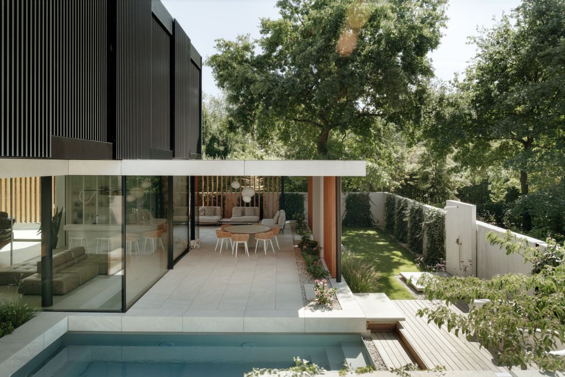 W Inside Out Villa basen, zadaszona jadalnia i miejsce do odpoczynku tworzą spójną strefę rekreacyjną otwartą na ogród i basen
