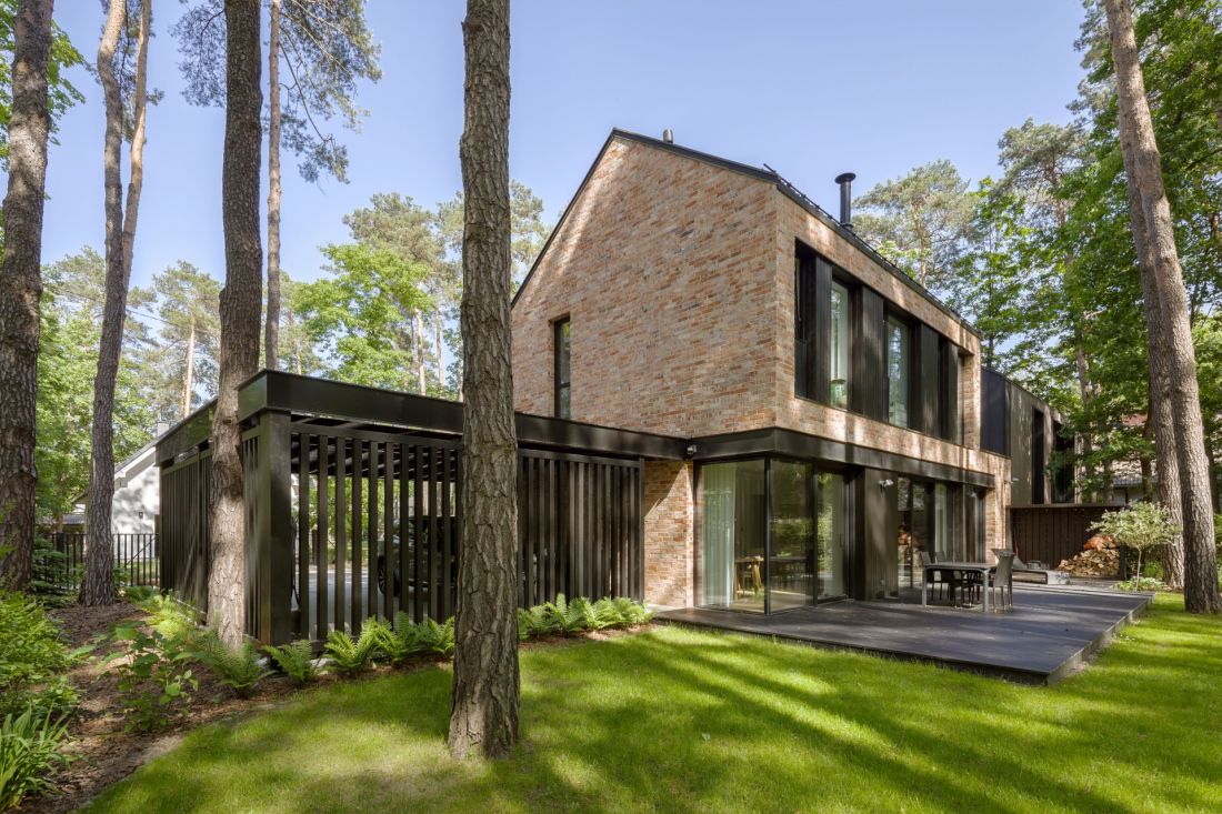 Przeszklenia na parterze łączą strefę dzienną z tarasem i sosnowym ogrodem
