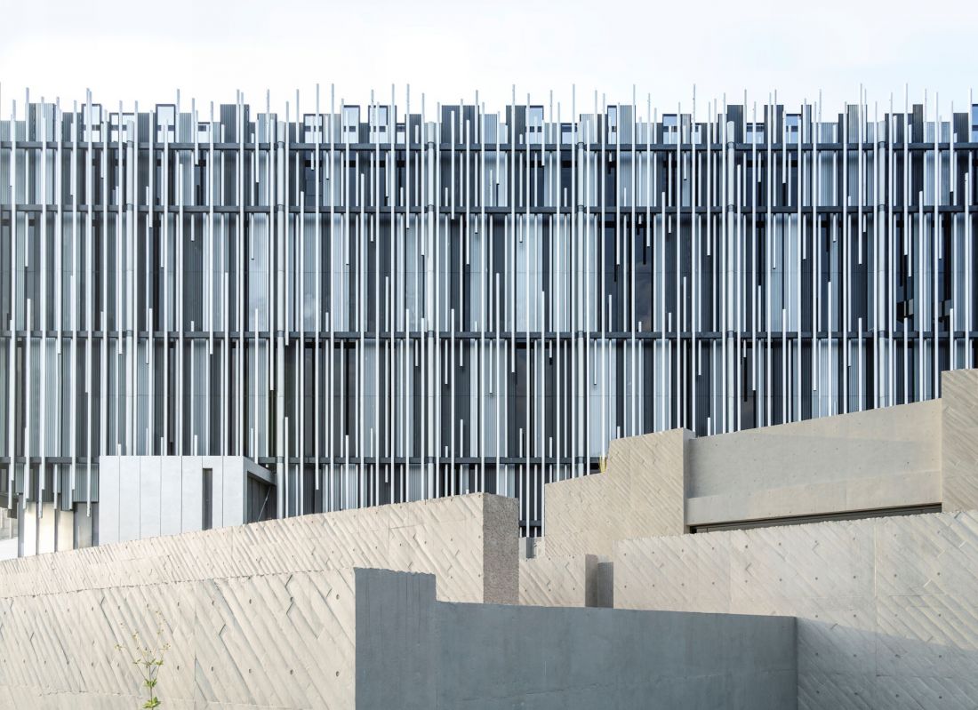 Warstwowa fasada muzeum została ukształtowana z pionowych aluminiowych profili o różnej długości i rytmie