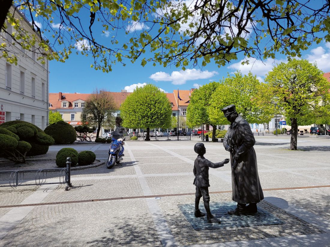 Rynek, pomnik Powstańca Wielkopolskiego odsłoniętego w 2018 roku, po lewej — ratusz