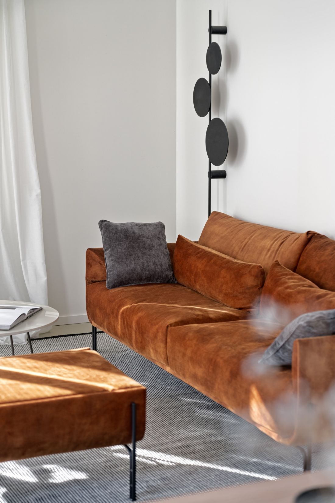 Mocnym akcentem kolorystycznym w salonie jest ruda sofa