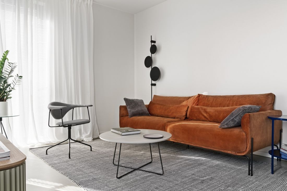Mocnym akcentem kolorystycznym w salonie jest ruda sofa