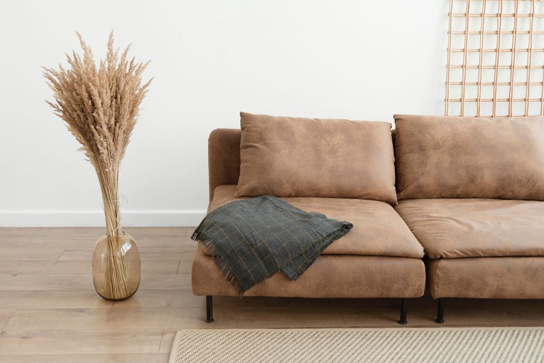 Brązowa sofa będzie wyglądać idealnie we wnętrzu w stylu boho