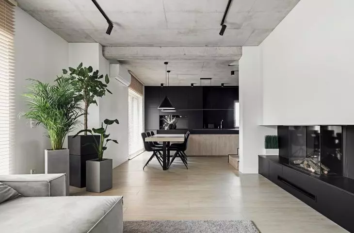 Reinforced concrete ceiling and dominant black. Minimalist interior of a house in Elizovka