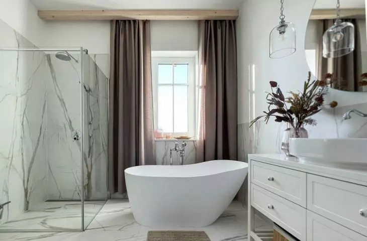 Przestronna łazienka wypełniona marmurem i jasnymi kolorami