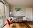 The living room wall is decorated with a painting by Małgorzata Łodygowska