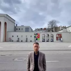 Radny Tomasz Dzionek na tle niemal bezdrzewnego placu przed Teatrem Fredry w Gnieźnie