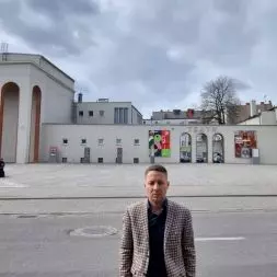 Radny Tomasz Dzionek na tle niemal bezdrzewnego placu przed Teatrem Fredry w Gnieźnie