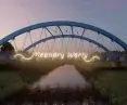 Widok na neon „Meandry Warty” na moście Światowego Dnia Roweru