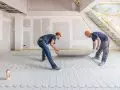 Montaż dodatkowej płyty gipsowo-włóknowej fermacell® o gr. 10 mm, która jest przyklejana i przykręcana jako przykrycie instalacji ogrzewania podłogowego fermacell® Therm 25
