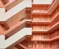 Modern building with pink coral balconies and zigzag staircases