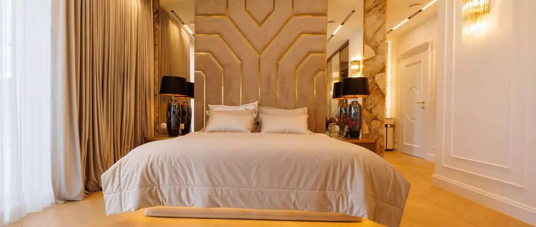 Master bedroom in gold and stone. New York style arrangement