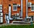 Klimatyzatory na ceglanej elewacji budynku