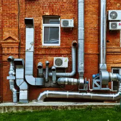 Klimatyzatory na ceglanej elewacji budynku
