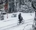 A man riding a bicycle on a snowy street