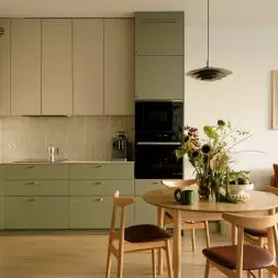 Krakowskie mieszkanie od Nona Studio łączy zieloną kuchnię, ciepłe drewno i klimat mid-century z funkcjonalnością potrzebną na co dzień