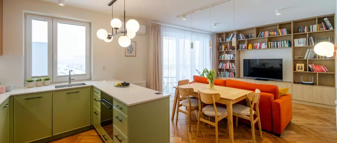 Zielona kuchnia i pomarańczowa sofa. 77-metrowe mieszkanie w Krakowie projektu ML STUDIO